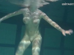 KiloTube presents: Naked brunette with big tits swims solo